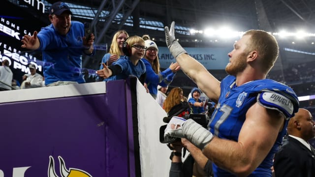 Detroit Lions defensive end Aidan Hutchinson celebrates the team's NFC North championship.